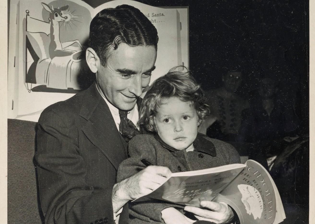 A man is reading a book to a little girl