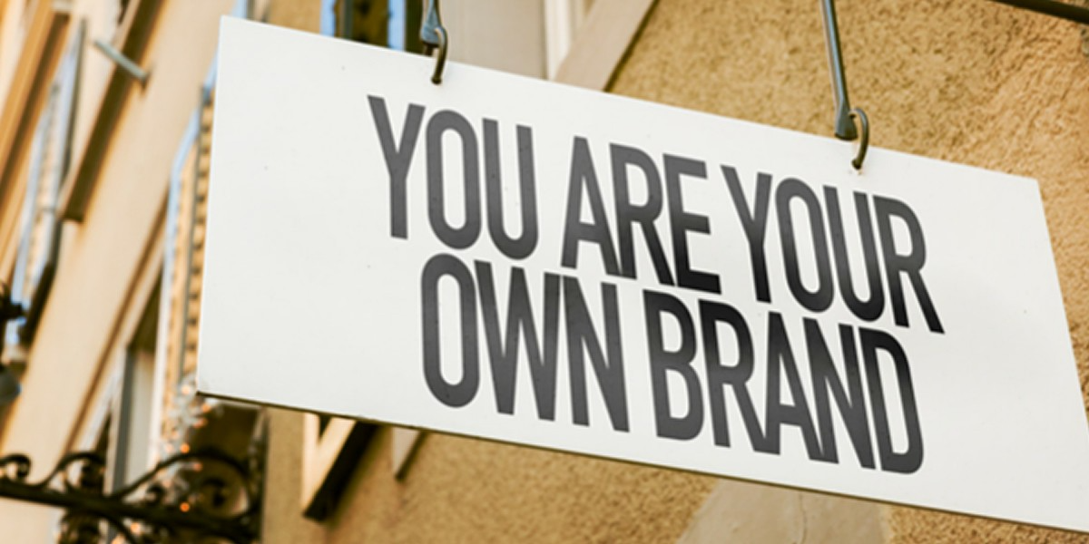 A sign that says you are your own brand is hanging on a building.