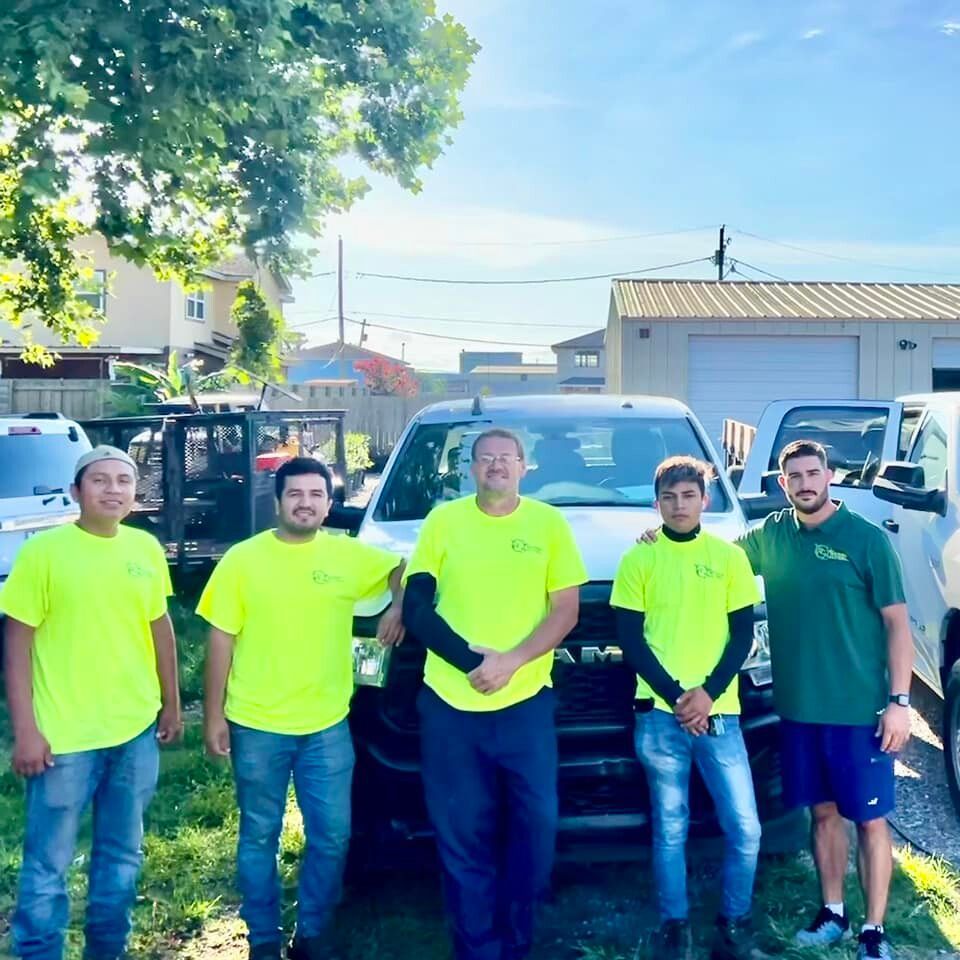 A group of men are posing for a picture in front of a truck