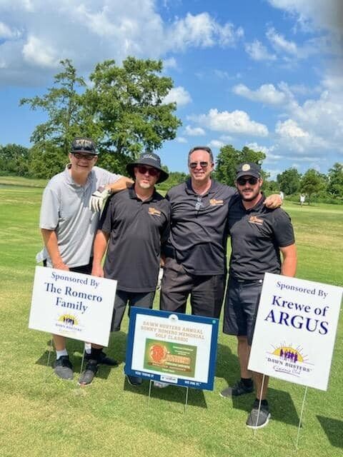 A group of men standing on a golf course with signs that say krewe of argus