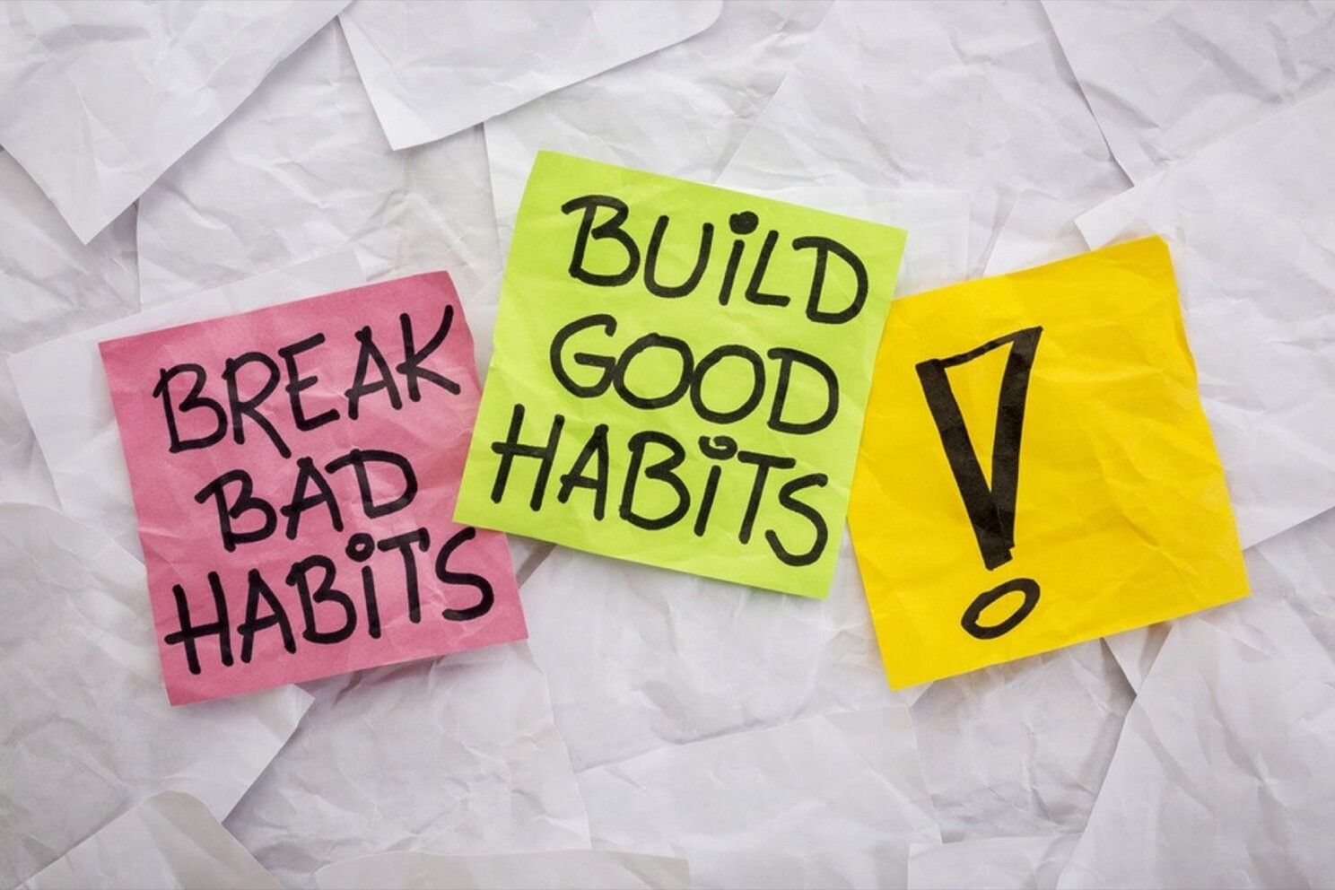 A bunch of sticky notes with the words `` break bad habits '' and `` build good habits '' written on them.