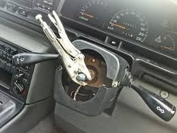 A pair of pliers is attached to the steering wheel of a car.