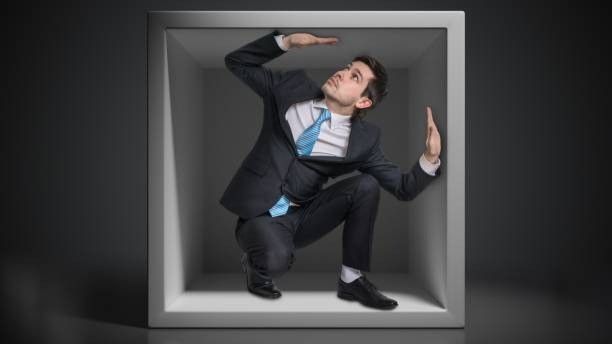 A man in a suit and tie is sitting in a box.