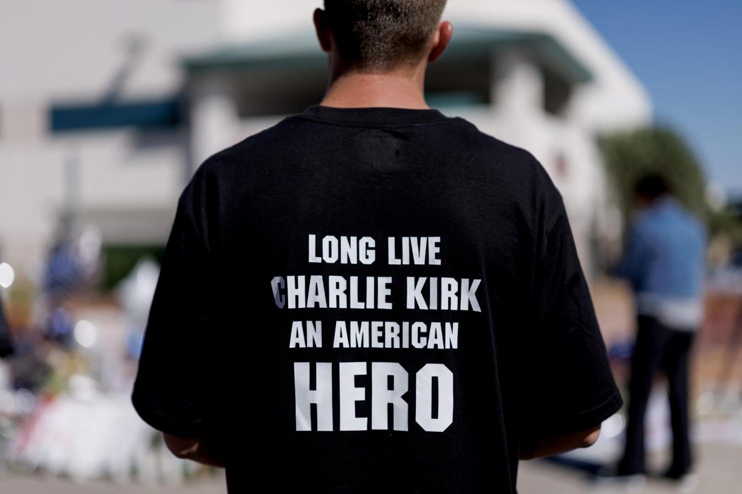 Man wearing a black shirt with white text: 