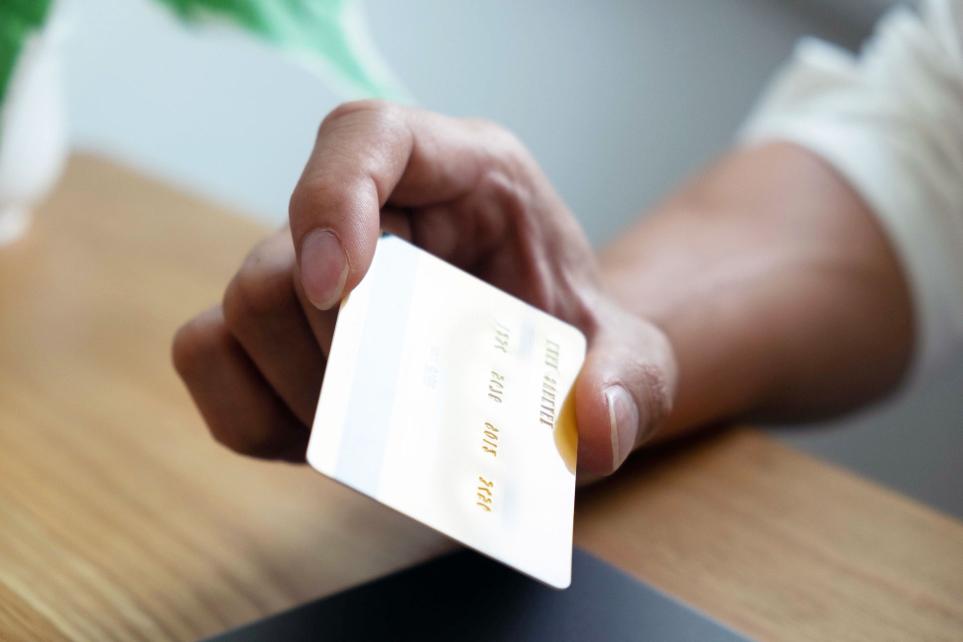 A person is holding a credit card in their hand.