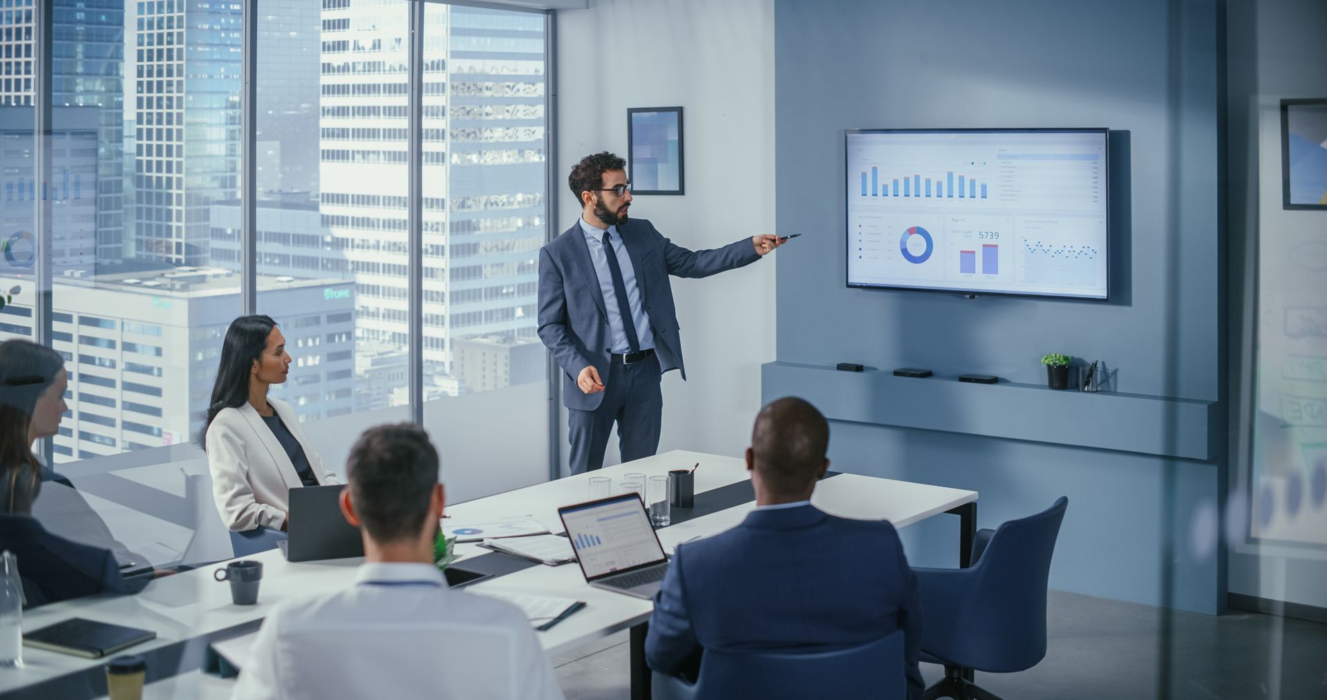 A man is giving a presentation to a group of people in a conference room.