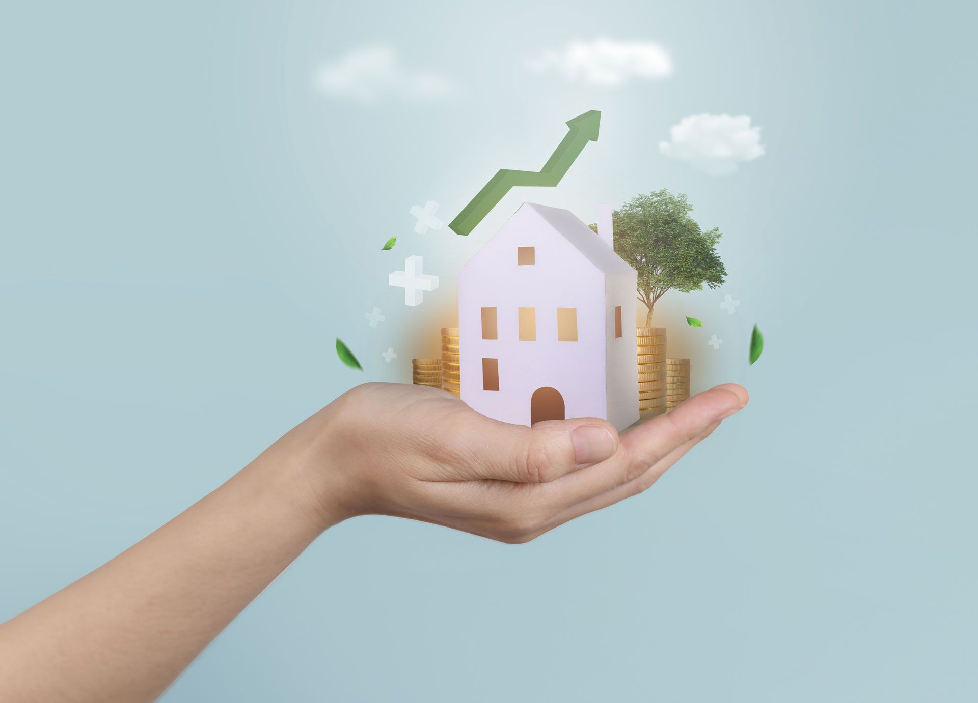 Hand holding a miniature house with a green upward arrow, coins, and a tree, symbolizing growth.