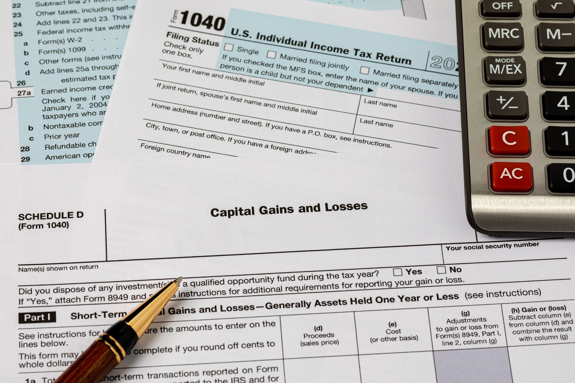 Tax forms and a calculator. A pen points to 