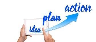 A person is holding a tablet with the words plan and action on it.
