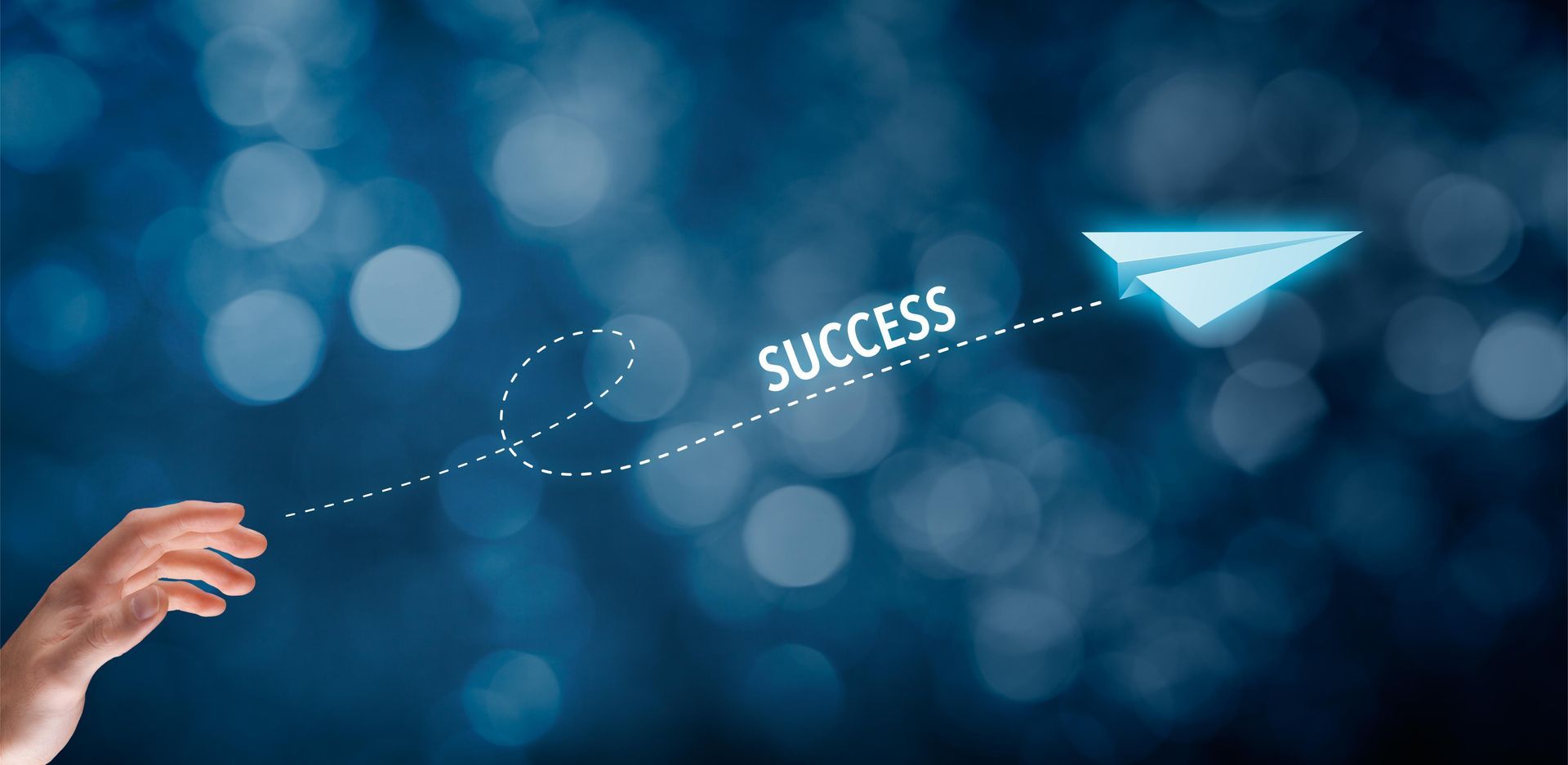 A person is drawing a paper airplane with the word success on it.
