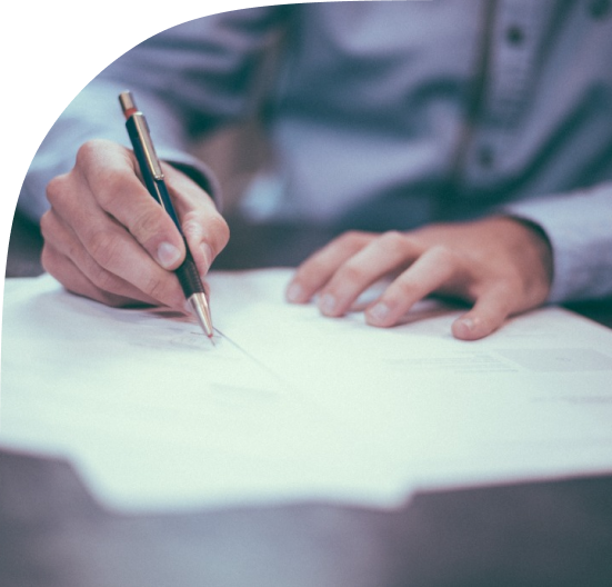 A person is writing on a piece of paper with a pen.