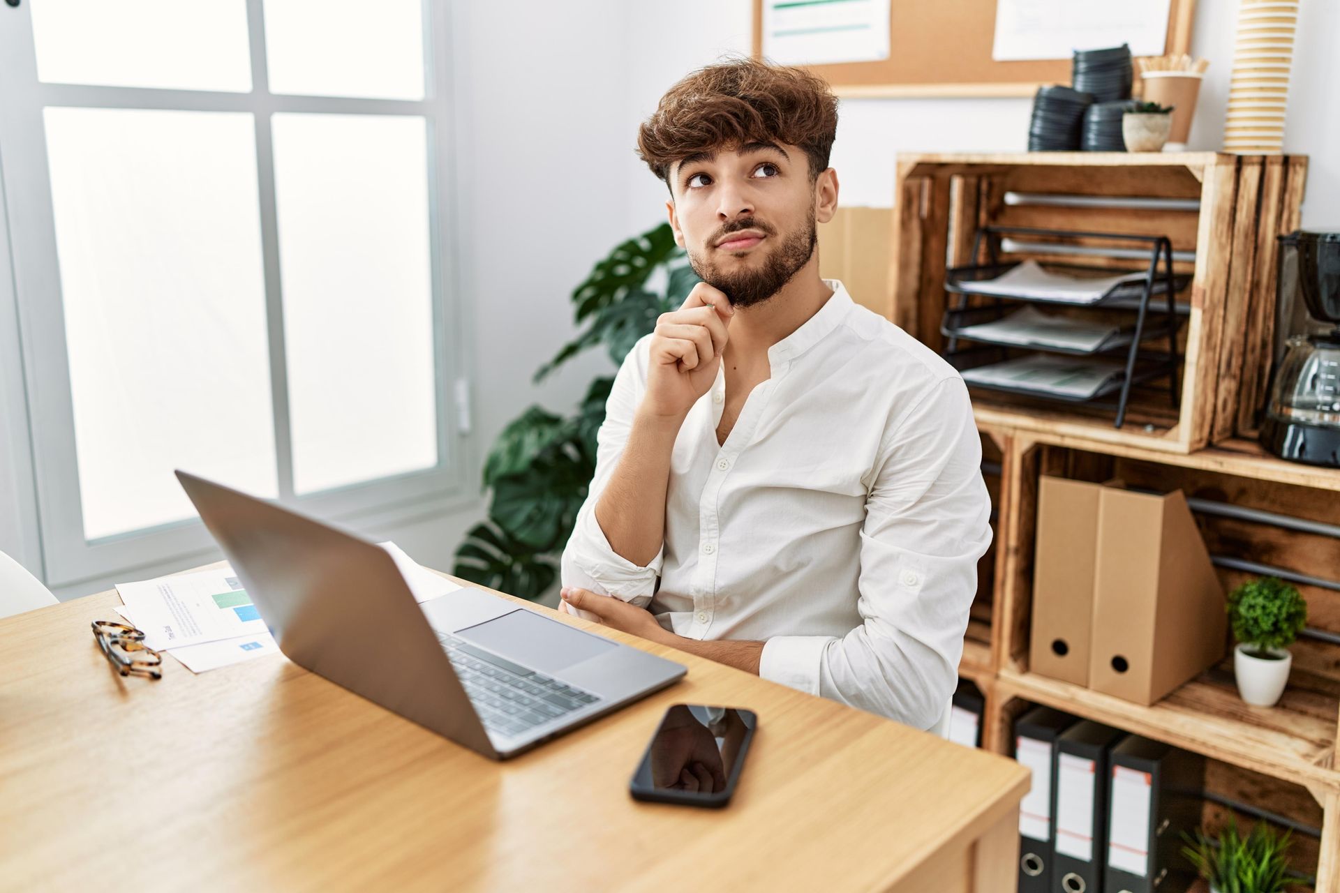 A man is sitting at a desk with a laptop computer.