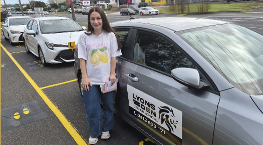 Woman standing beside a gray car in a parking lot, wearing a white T-shirt and jeans. Woman standing beside a gray car in a parking lot, wearing a white T-shirt and jeans.