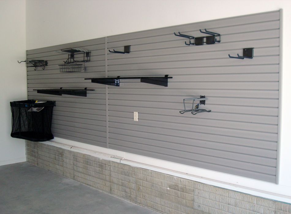 Garage organization system with gray slatwall, various storage hooks, and a net bag.