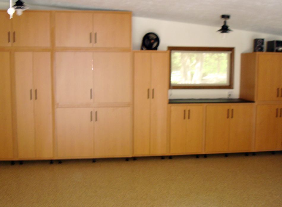 Garage with light brown cabinets, a window, and a black countertop.