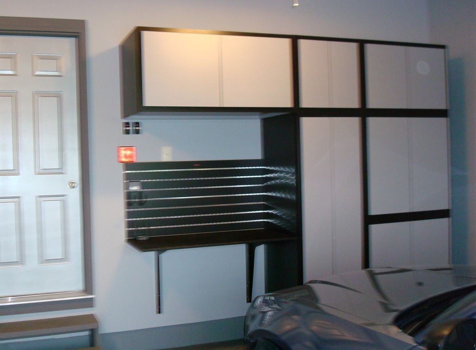 Garage storage system with cabinets, a workbench, and a car.