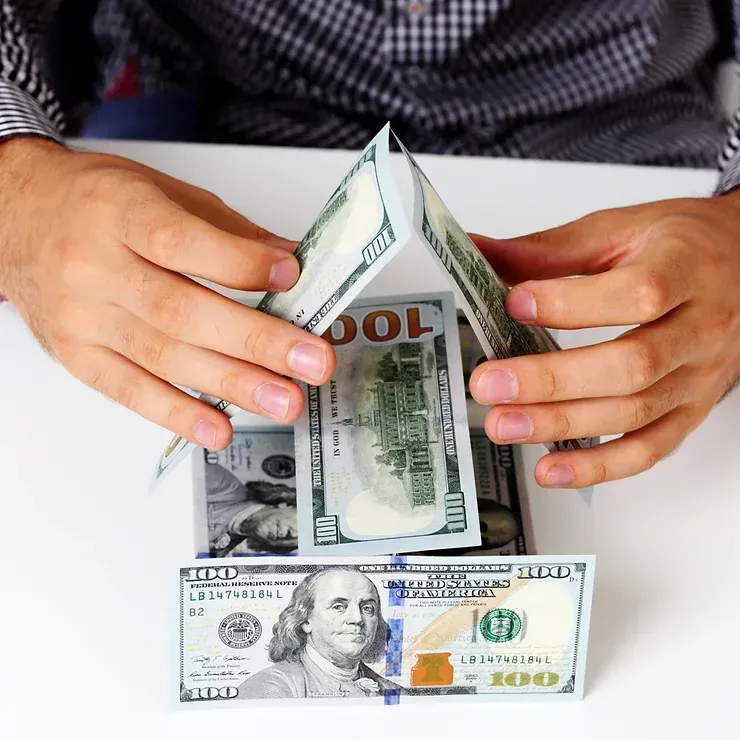 A man is stacking 100 dollar bills on top of each other