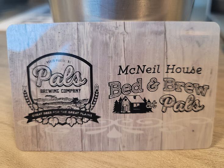 Gift card for McNeil House Bed & Brew Pals, with brewery logo on a woodgrain background.