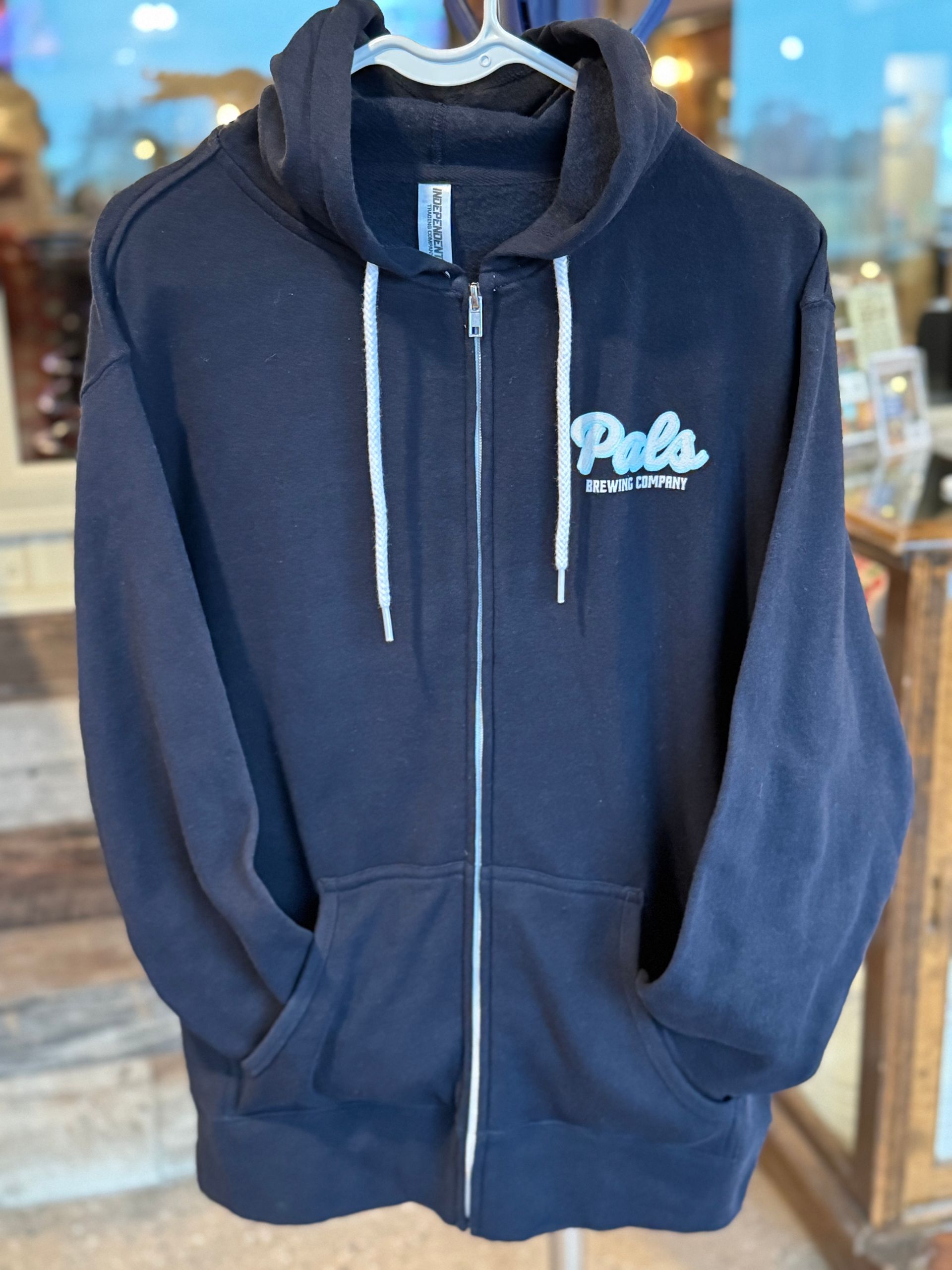 Navy blue zip-up hoodie with white drawstring and logo on the chest.