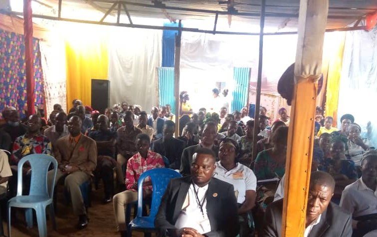 A large group of people are sitting in chairs in a room.