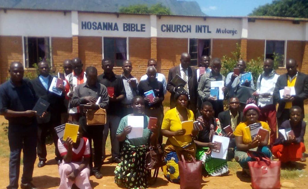 A group of people are posing for a picture in front of a church.