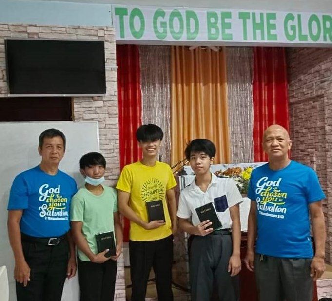 A group of people standing in front of a sign that says to god be the glory