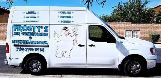 A frosty 's air conditioning van is parked on the side of the road.