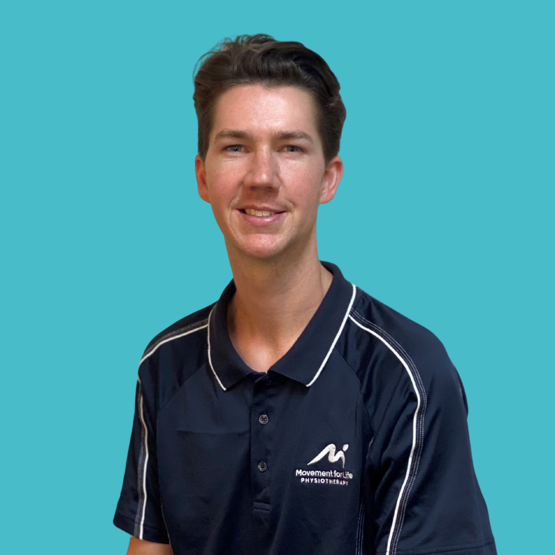 Woman in a navy polo shirt standing against a turquoise background.