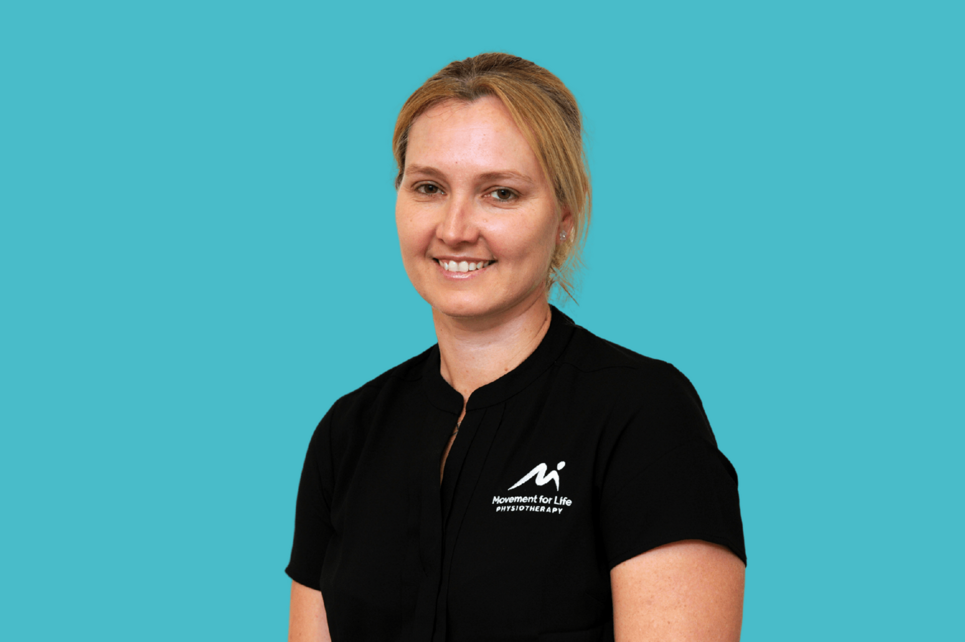 Smiling person in a black shirt against a light blue background