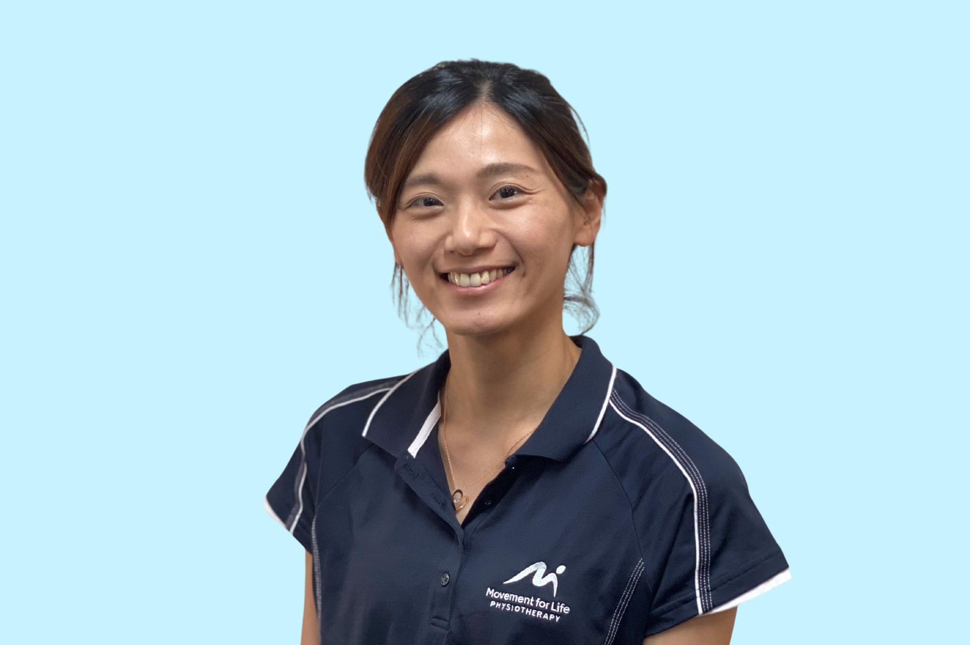 Smiling person in a navy polo shirt against a turquoise background.