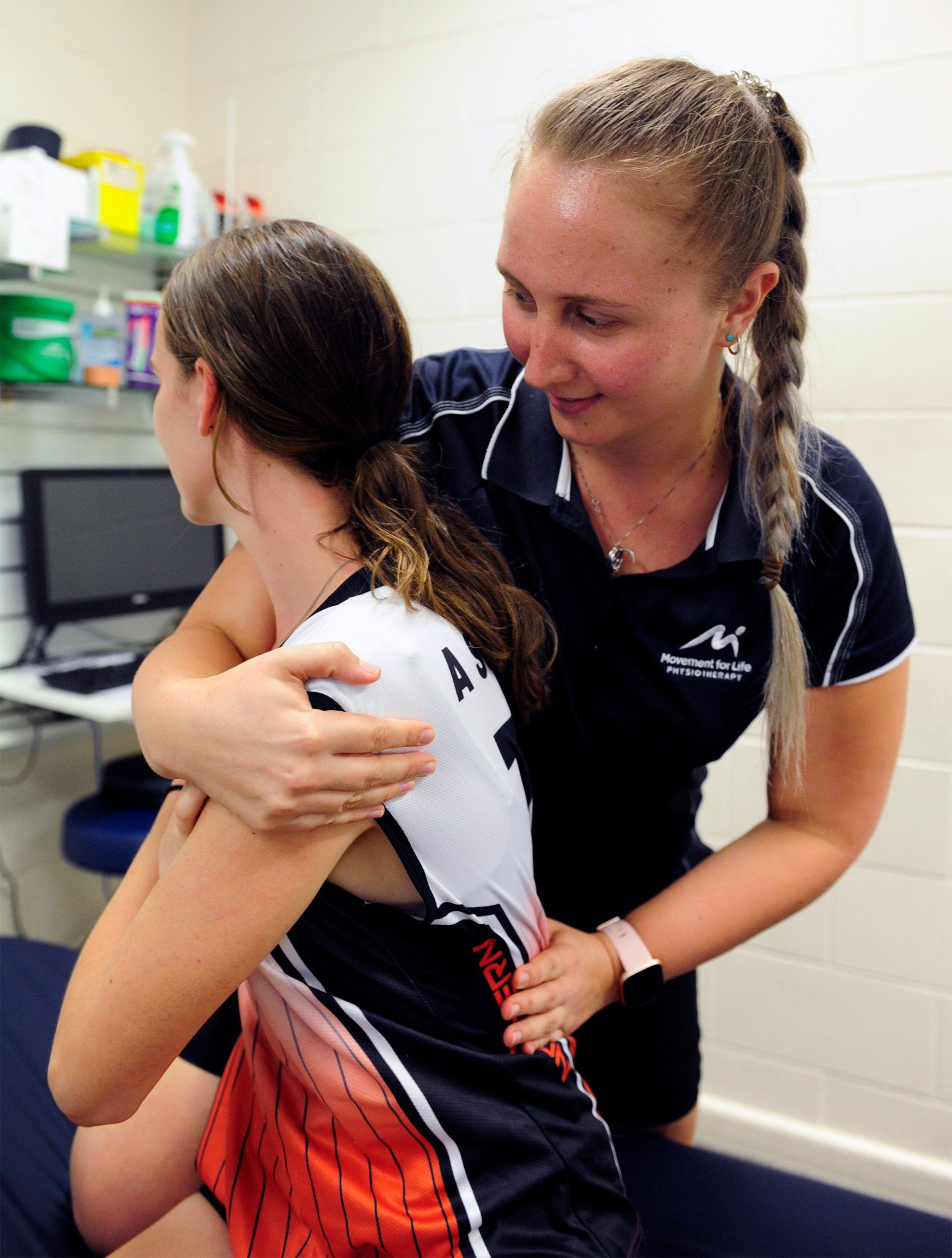 Physical therapist helping a patient with back treatment in a clinic room