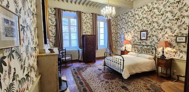 une chambre avec un lit, des tables de nuit, des lampes et un tapis.