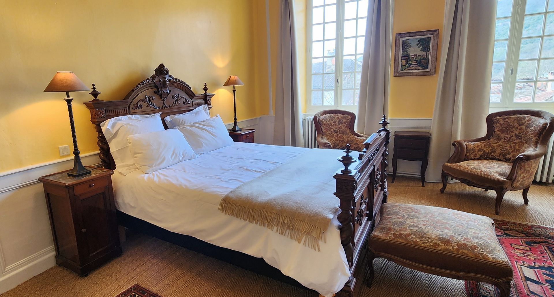 une chambre avec un lit , des chaises , des tables de nuit et des lampes .