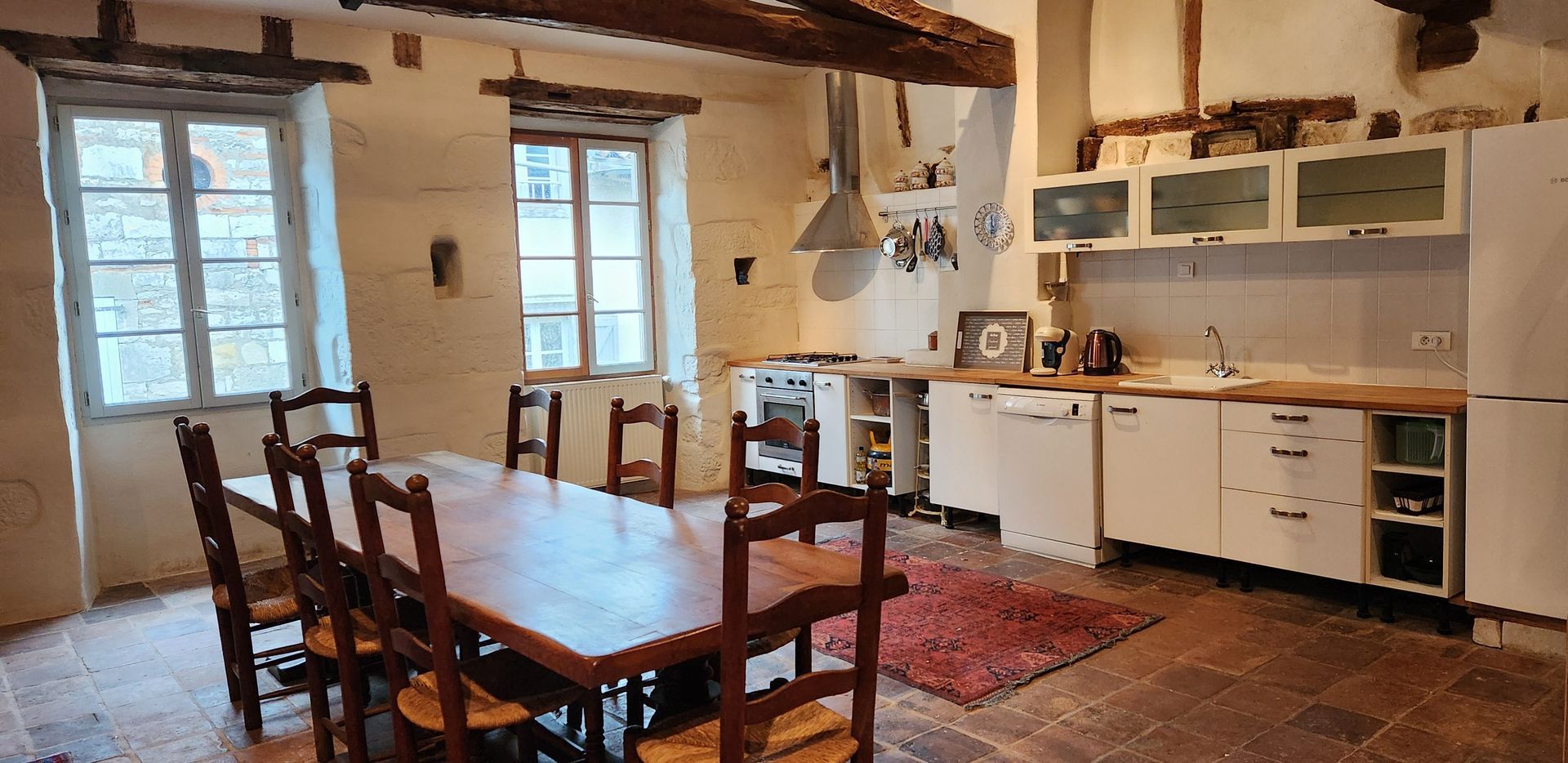 a kitchen with white cabinets and a red rug on the floor .