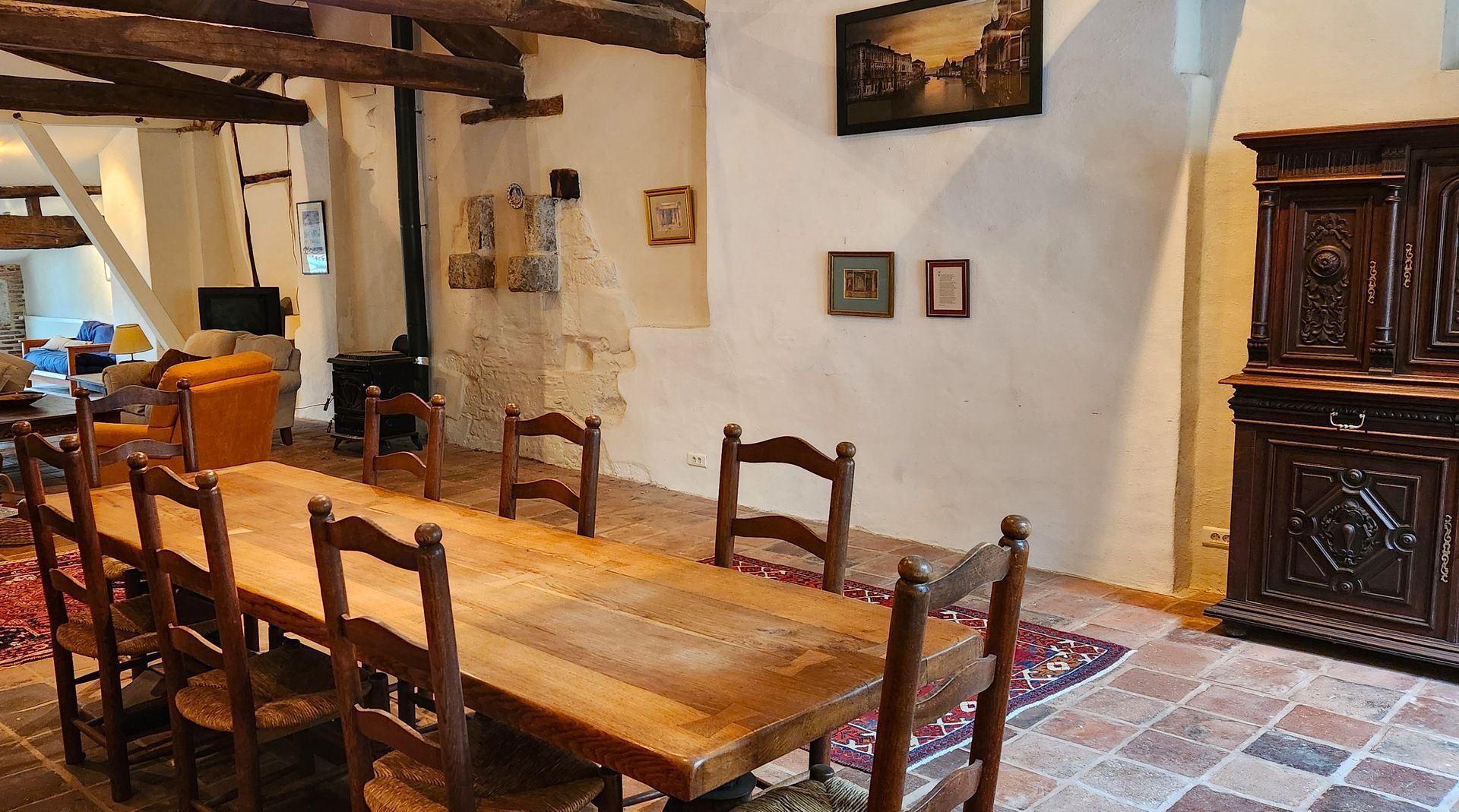 A dining room with a long wooden table and chairs.