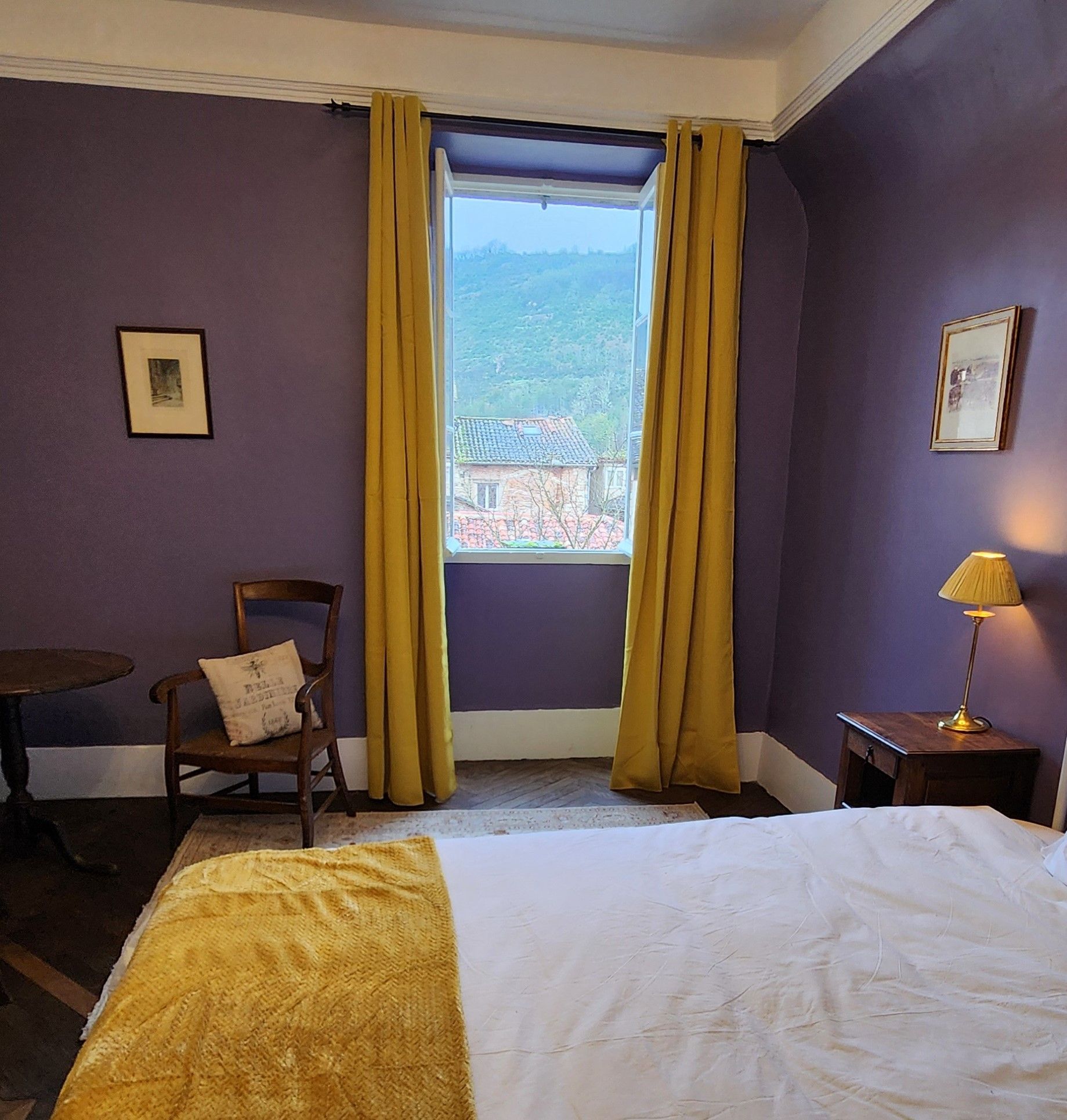 A bedroom with purple walls and yellow curtains