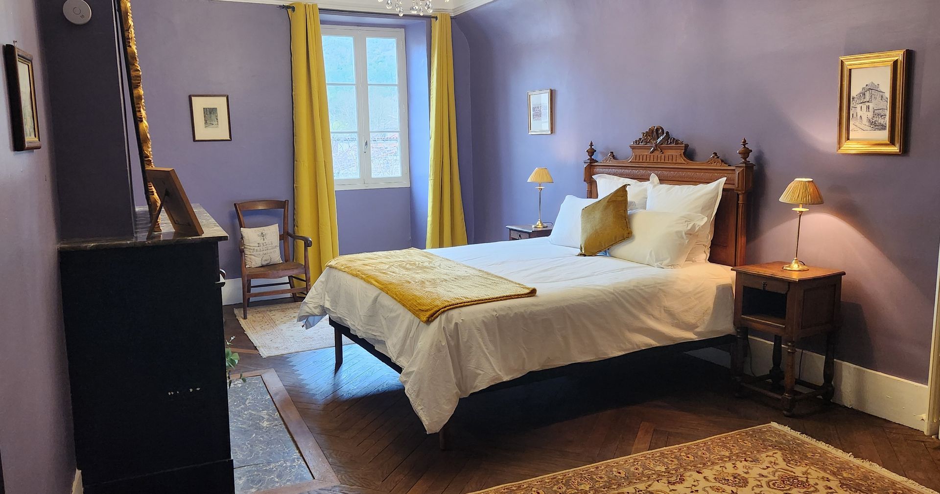 A bedroom with purple walls and a large bed.