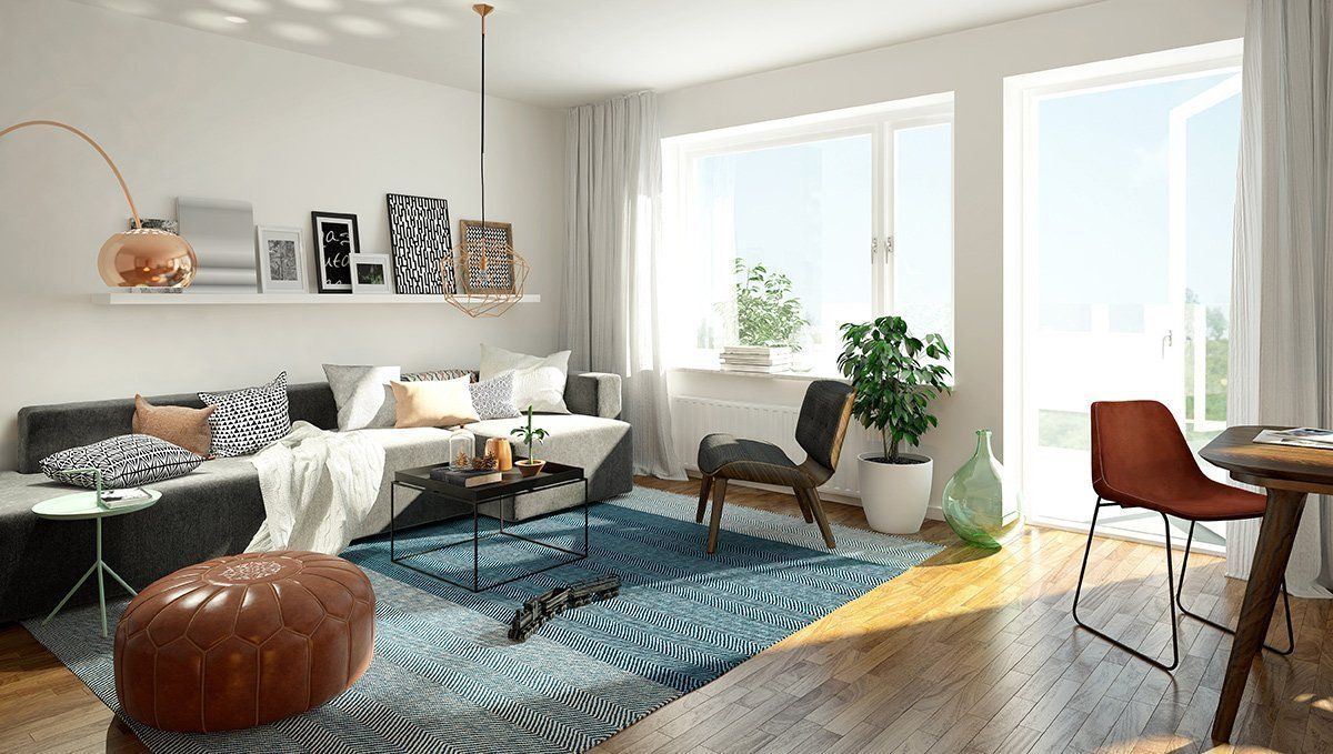 Bright modern living room with gray sofa, blue patterned rug, wooden chairs, and large windows.