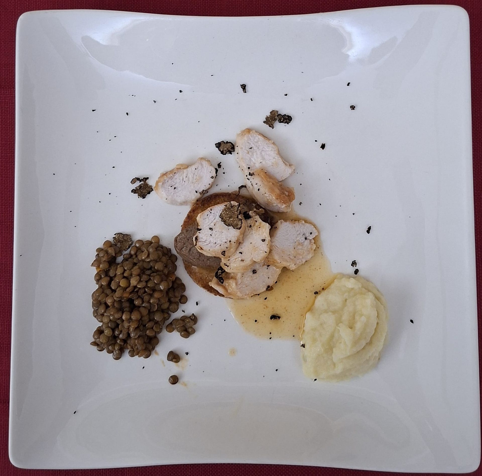 Piatto elegante con due cappelli di funghi, salsa gialla e guarnizione di foglie verdi.