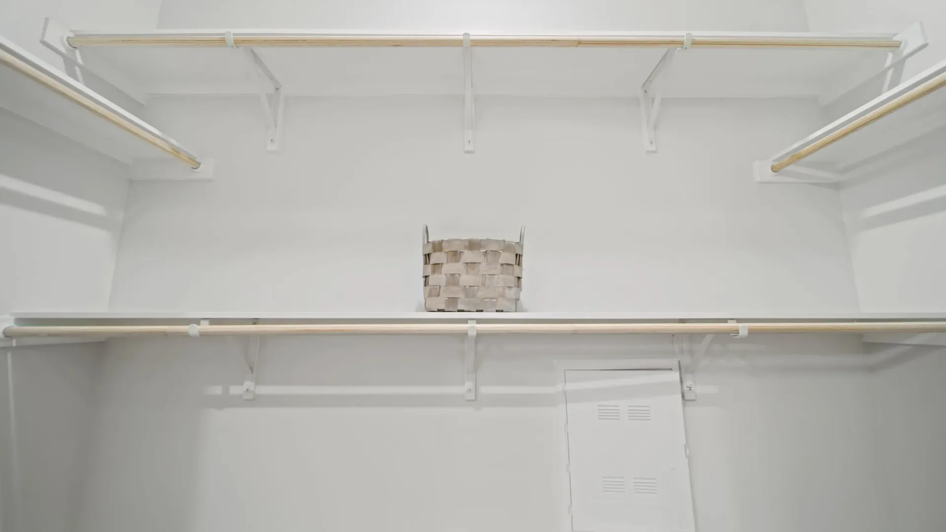 Empty walk-in closet with shelves and hanging rods