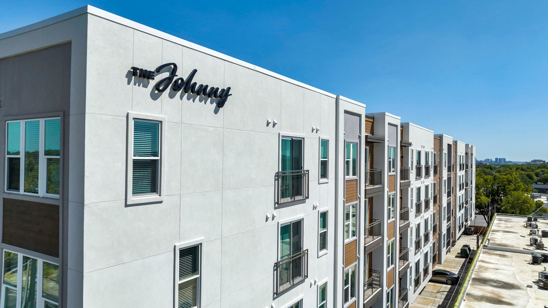 Modern apartment building exterior with white and gray facade and blue windows under a clear sky