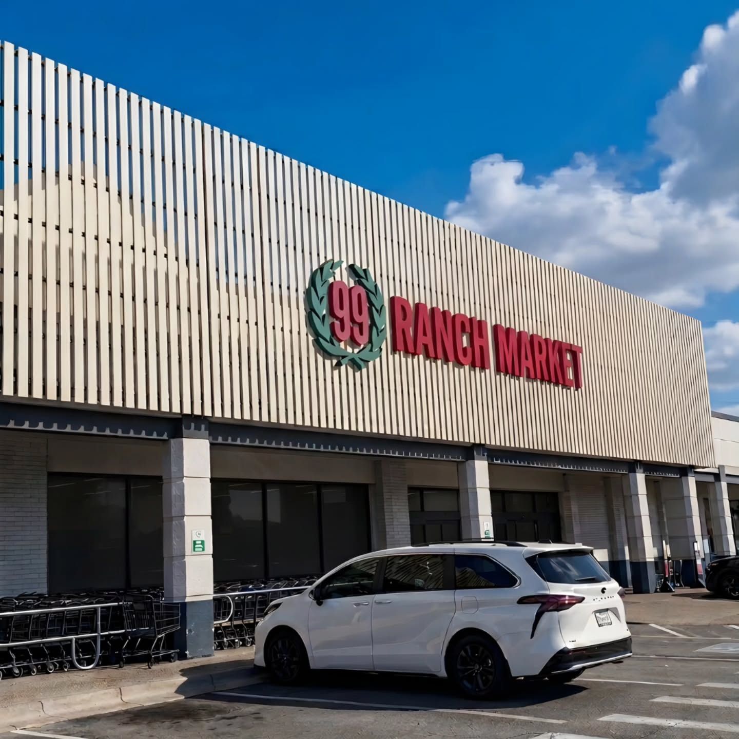 Ranch Market storefront with white SUV parked outside under a blue sky