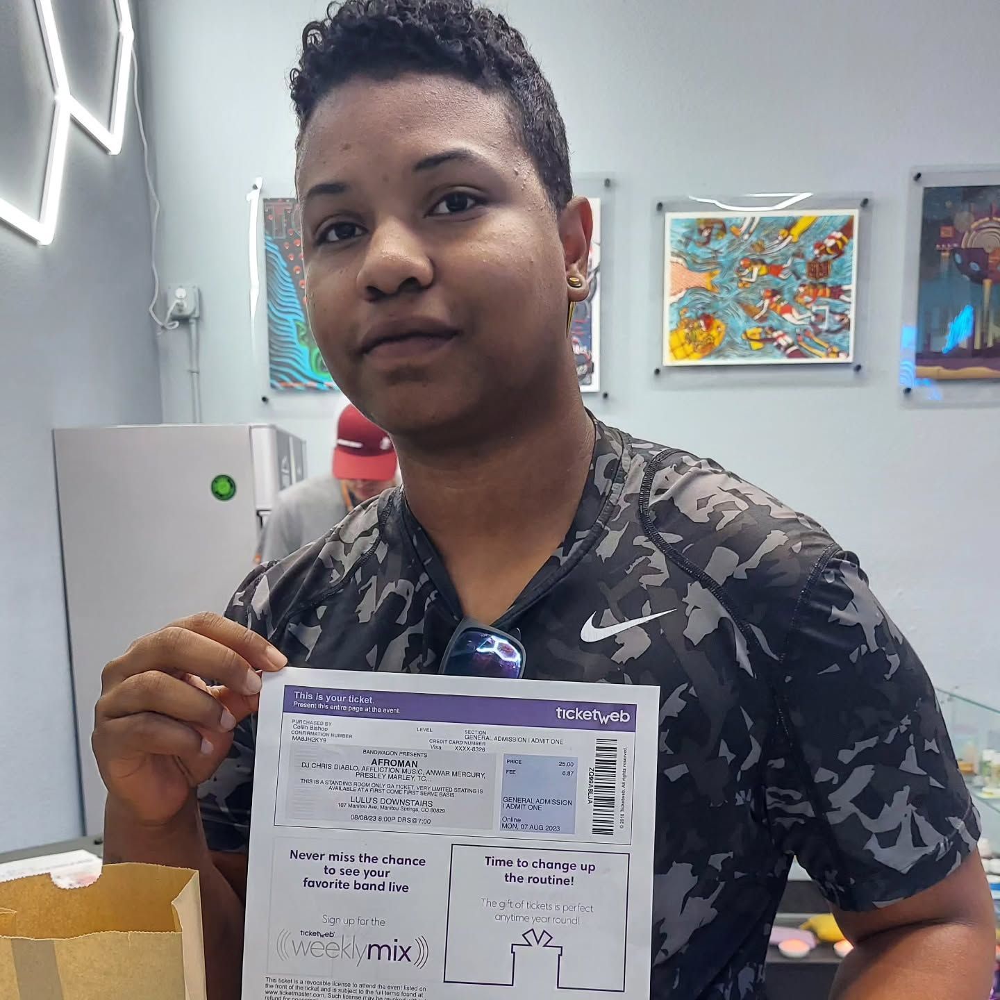 Person holding a document inside a store with art on the walls.