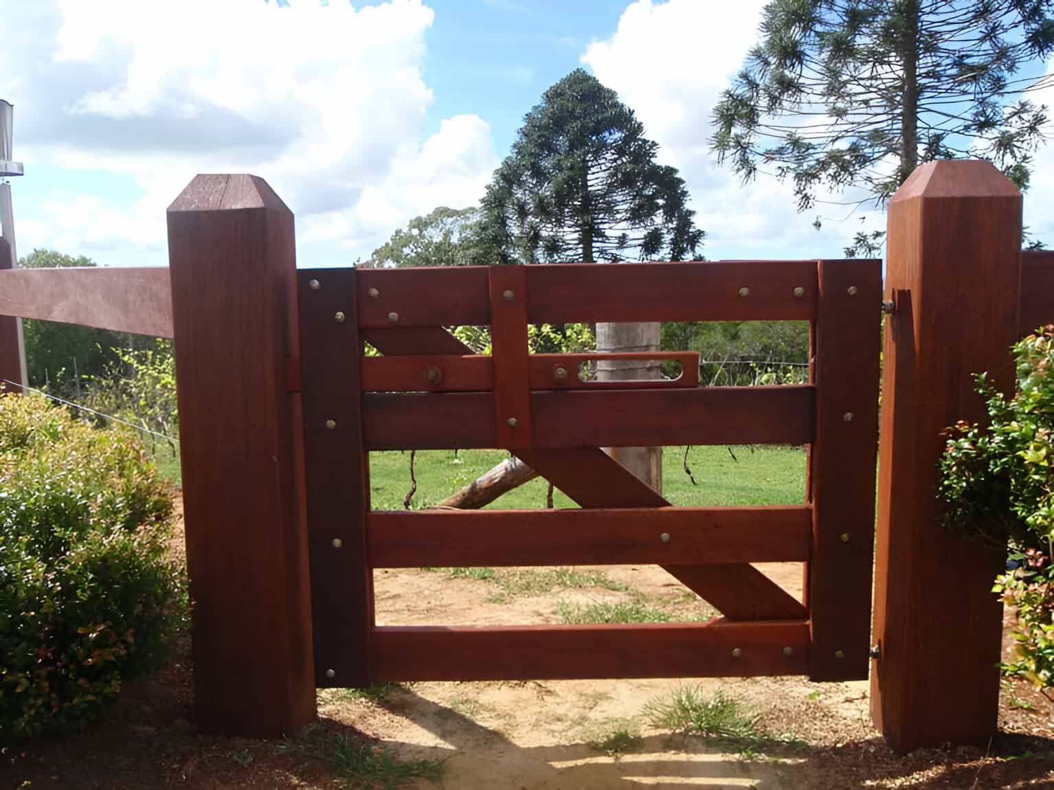 A Wooden Gate Leading To A Field With Trees In The Background — John Stark Fencing In Cooroy, QLD