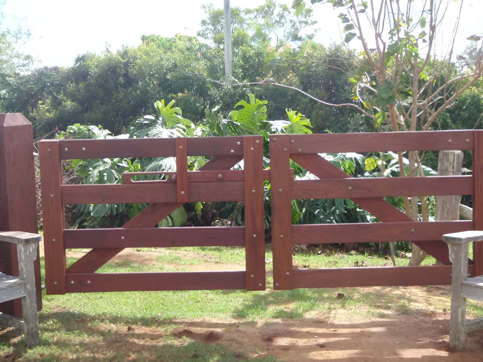 A Wooden Gate Is Open To A Lush Green Field — John Stark Fencing In Nambour, QLD