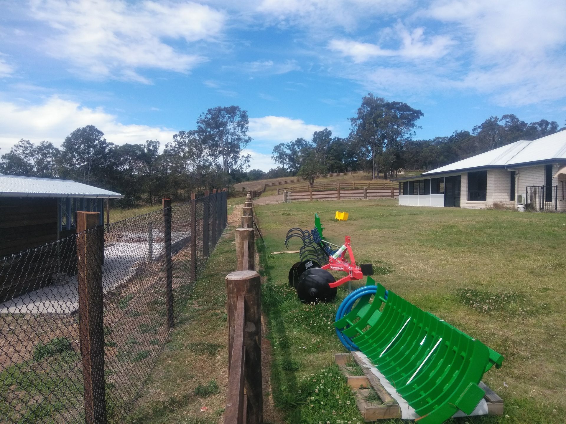 Rural Fence Next To A Wooden Fence In Front Of A Yard — John Stark Fencing In West Woombye, QLD