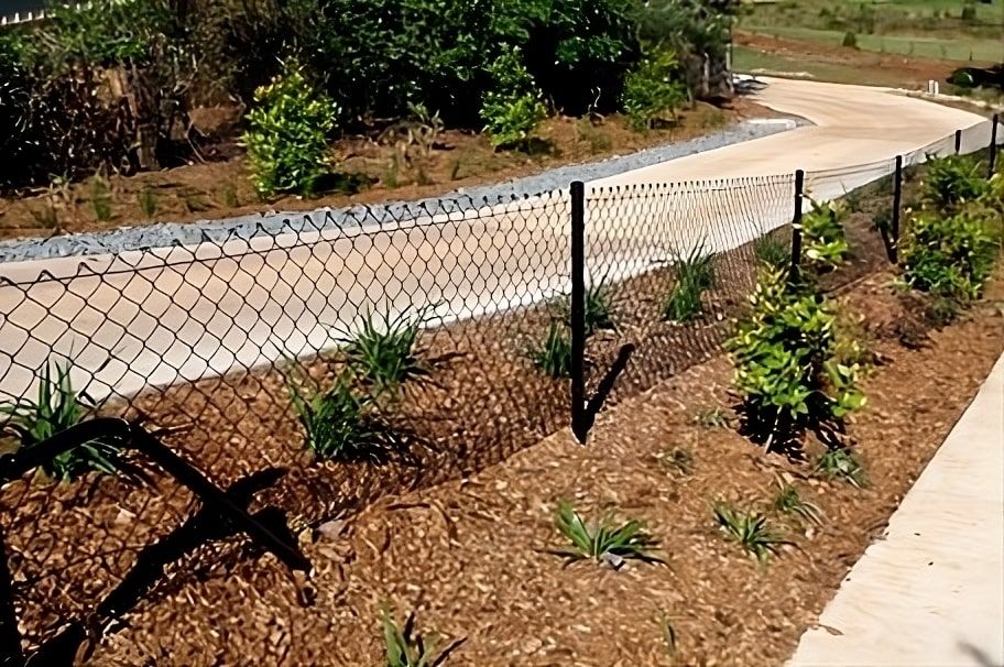 A Chain Link Fence Surrounds A Lush Green Garden — John Stark Fencing In Nambour, QLD