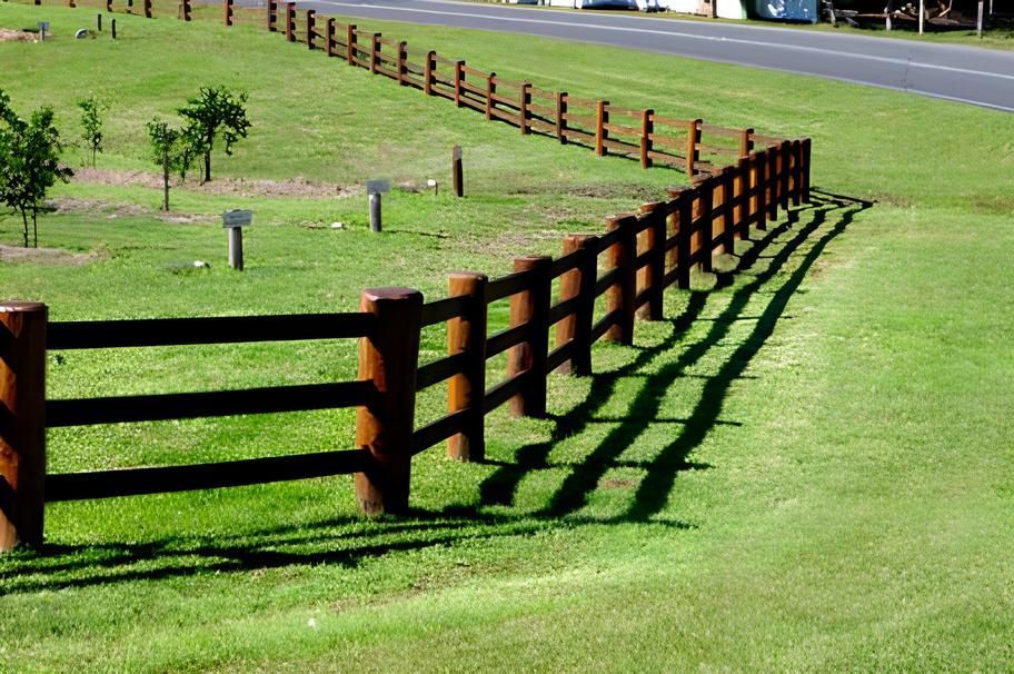 A Wooden Fence Surrounds A Lush Green Field — John Stark Fencing In Bli Bli, QLD
