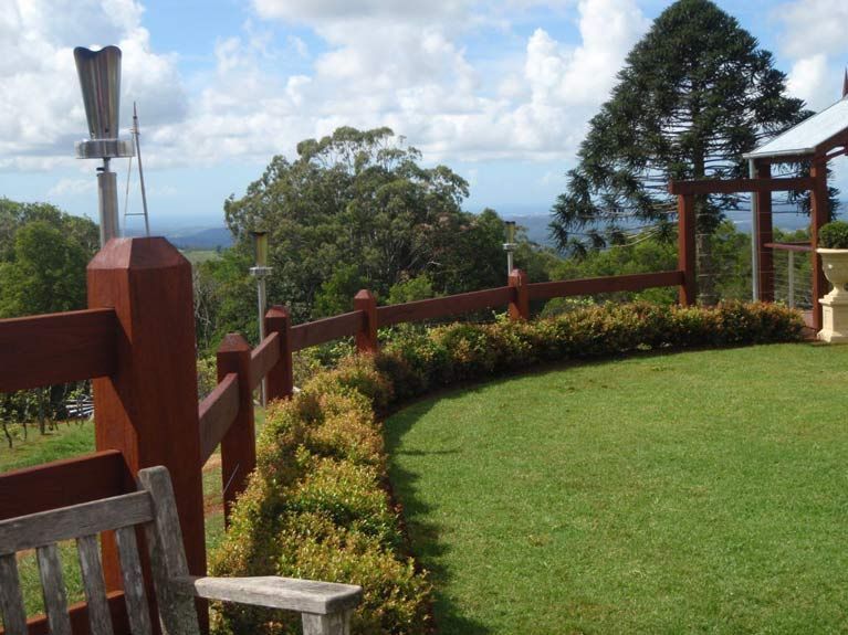 A Wooden Fence Surrounds A Lush Green Field — John Stark Fencing In Bli Bli, QLD
