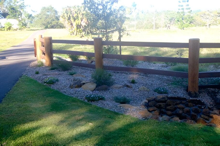 A Wooden Fence Is Surrounded By Rocks And Grass — John Stark Fencing In Bli Bli, QLD
